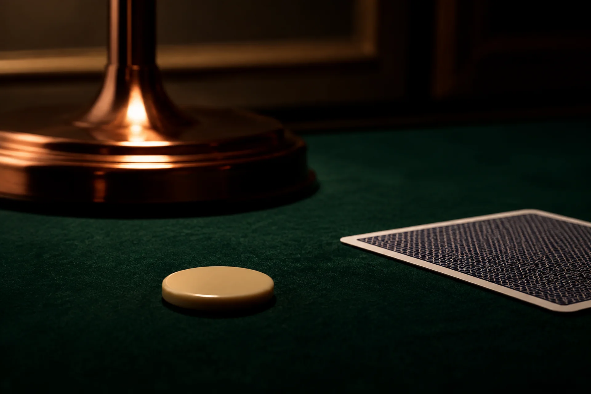 Abstract token and copper lamp on green felt